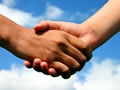 Handshake against blue sky